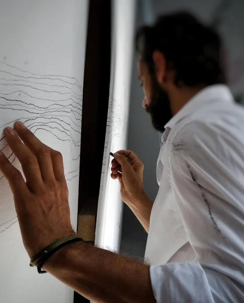 A man drawing on a wall by hand