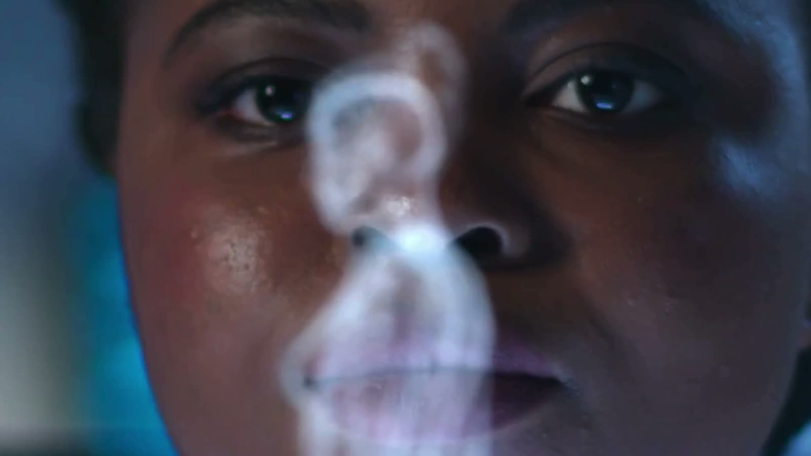 A close view of a face lit by the light of a projected data display